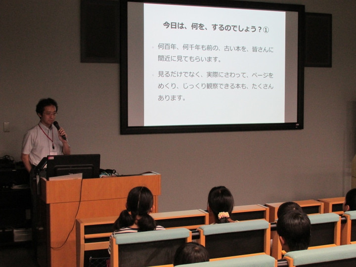 「大学発・政策提案制度」事業_昔の本にさわってみよう！：ホールにて説明（２０１４年７月２２・２３日豊岡小学校）